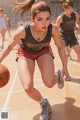 A woman in a basketball uniform dribbling a basketball on a court.