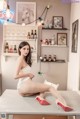 A woman sitting on top of a white table.