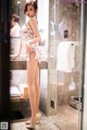 A woman standing in a bathroom next to a shower.