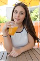 A woman sitting at a table with a glass of orange juice.