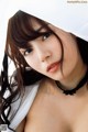 A woman with long brown hair wearing a white shirt.