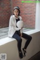 A woman sitting on a ledge holding a volleyball.