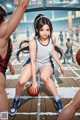 A girl in a basketball uniform dribbling a basketball on a court.