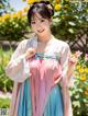 A woman in a pink and blue dress posing for a picture.