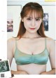 A woman in a green bra top is posing for a picture.