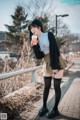 A woman standing on a sidewalk holding a cup of coffee.