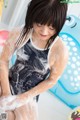 A woman in a bathing suit is washing her hands.