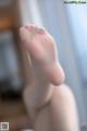 A close up of a person's bare feet on a window sill.