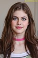 A woman with long brown hair wearing a pink choker.