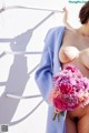 A naked woman holding a bunch of flowers.