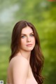 A woman with long brown hair and blue eyes posing for a picture.