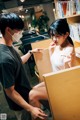 A man and a woman wearing face masks in a library.